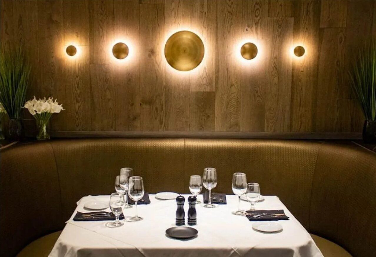 Restaurant dining booth with a row of warm wall sconces